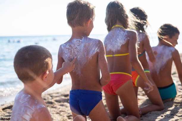 istock Rear view children playing with suntan lotion 1149133042