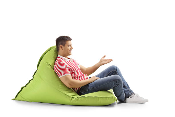 istock Young man sitting on a green bean bag and gesturing with hand 1149134271