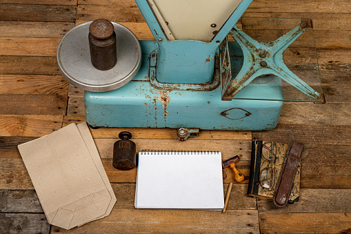 Equipment of the old store. Weight, notebook and goods on the shop table. Dark background.