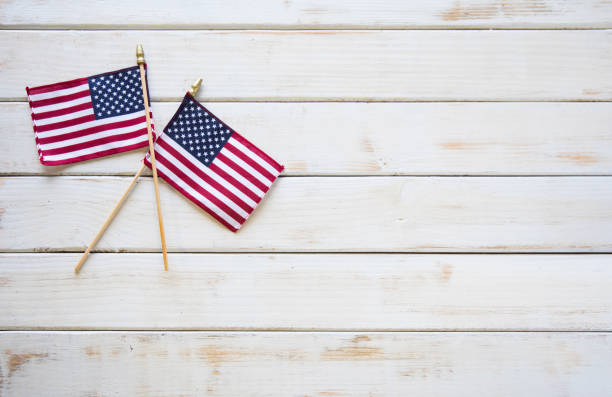This is a close up photo of two American flags on and old retro white wooden table. This is a great image for memorial day, veterans Day, etc.