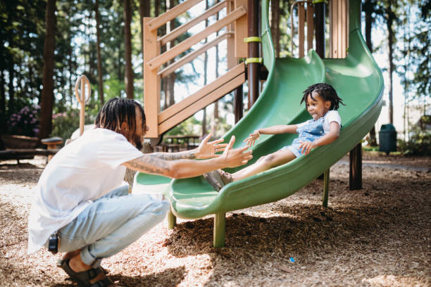 istock Father Helping His Child On Playground Slide 1149137509