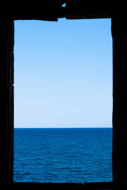 Crumbling window frame overlooking the sea of Sicily, Italy