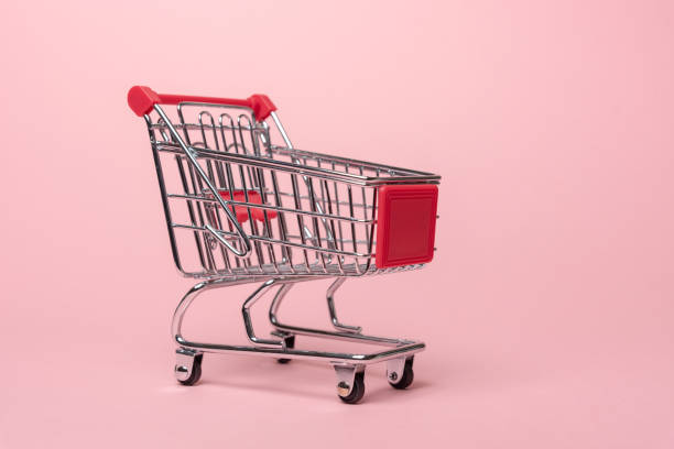Shopping cart on pink background stock photo