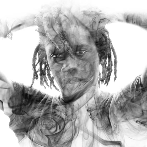 istock Double exposure of a dark skinned man with dreadlocks and hands behind head combined with a photograph of smoke flowing in the air 1149146641