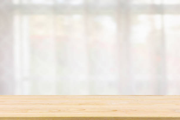 istock Empty wood table top with window curtain abstract blur background for product display 1149156854