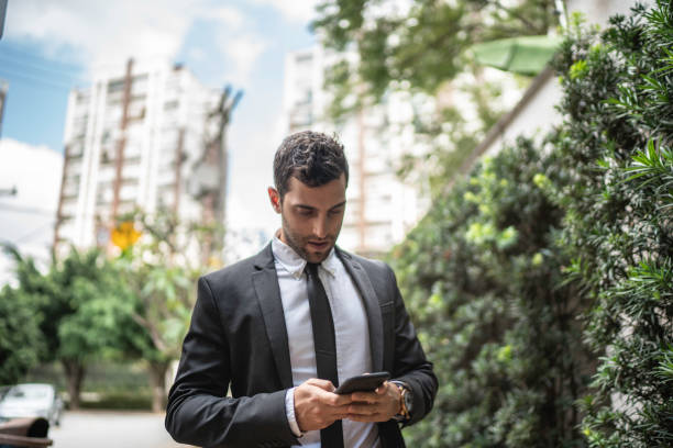 istock Businessman walking and using cellphone in the street 1149157736