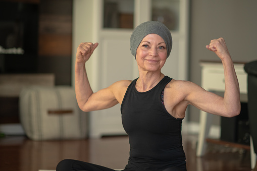 Mujer mayor con cáncer que se está flexieando photo