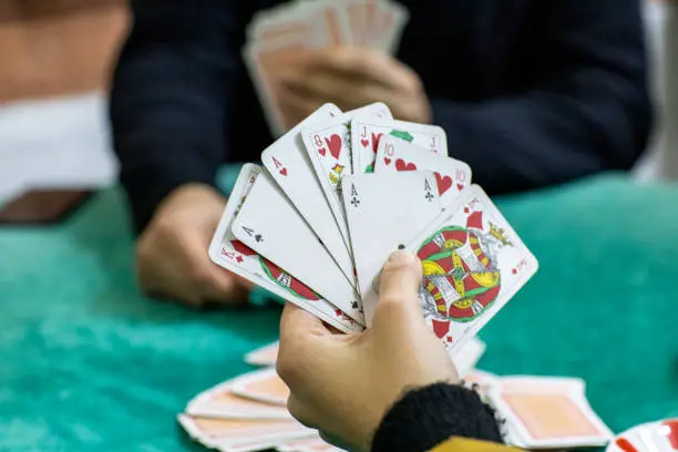 Photo of Young couple playing playing card game, cards.