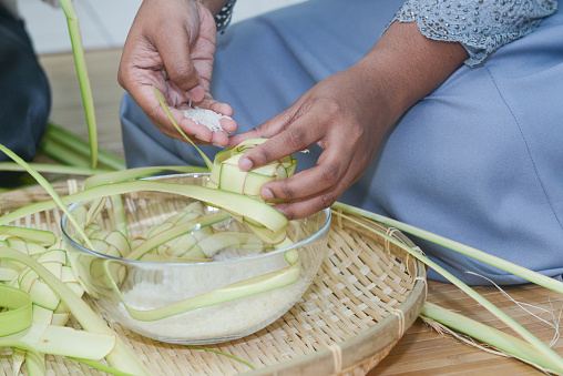 Close-up Malaysian woman prepare 'ketupat', a traditional delicacy serve during Eid-Ul-Fitr celebration