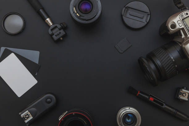 istock Photographer workplace with dslr camera system, camera cleaning kit, lens and camera accessory on dark black table background 1149168141
