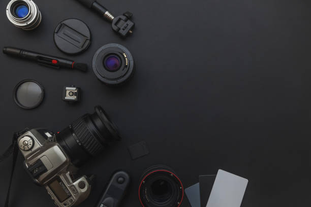 istock Photographer workplace with dslr camera system, camera cleaning kit, lens and camera accessory on dark black table background 1149168145