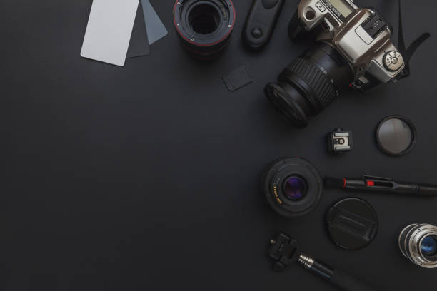 istock Photographer workplace with dslr camera system, camera cleaning kit, lens and camera accessory on dark black table background 1149168153