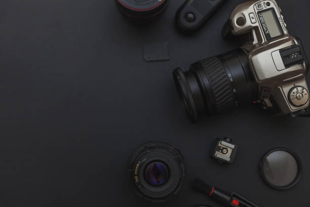 istock Photographer workplace with dslr camera system, camera cleaning kit, lens and camera accessory on dark black table background 1149168161