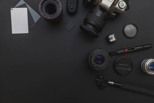 istock Photographer workplace with dslr camera system, camera cleaning kit, lens and camera accessory on dark black table background 1149168167