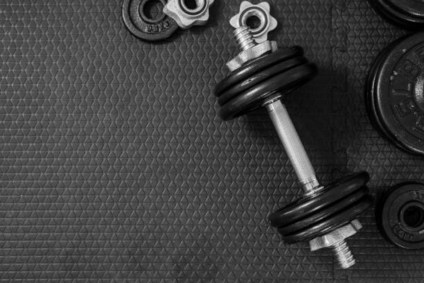 istock Top view of Iron dumbbells or weights on black floor with copy space for text. Flat lay composition. Health care concept. 1149170006