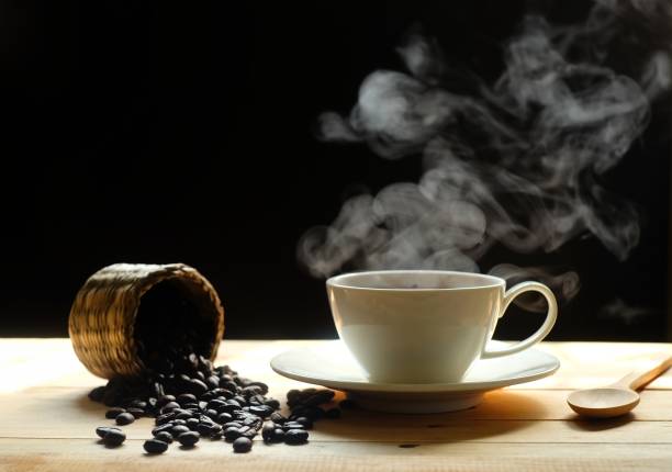 istock hot coffee and coffee beans with smoke on wooden table dark background 1149170708