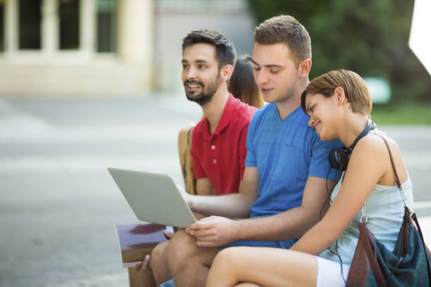 istock Young and happy group of students sitting outdoors in campus 1149171024