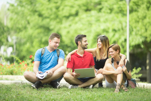 istock Young students with laptop outdoors in park 1149172639