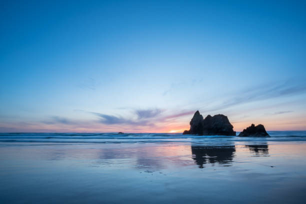 ちょうど沖合の大きな岩とオレゴンビーチで夕日の風景画像 - oregon beach ストックフォトと�画像