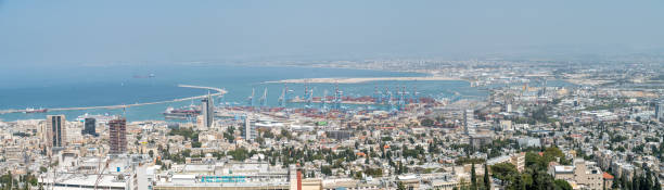 view of the haifa docks with downtown haifa in the background - comerce imagens e fotografias de stock