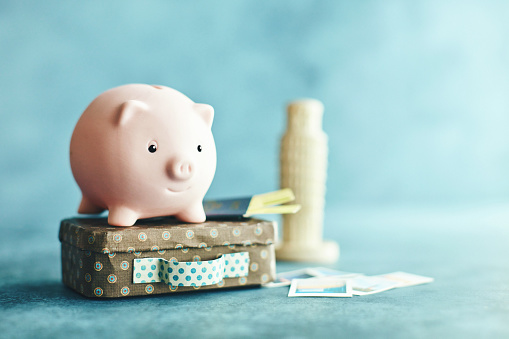 Little pink piggy bank on vacation. Conceptual image to portray saving for a vacation to Italy.