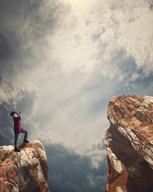 istock Man looking through binoculars to a higher mountain peak 1149179127