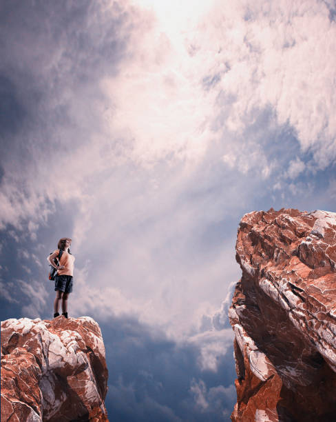 Traveler looking up to a higher mountain peak over a gap between.