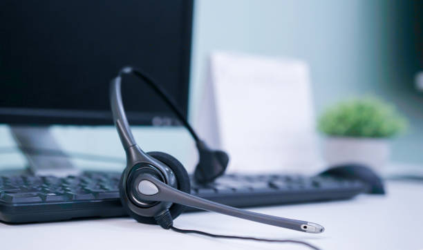 istock close up headset of call center and VOIP for communication technology on office desktop pc  in monitoring room for network operation job concept 1149180921