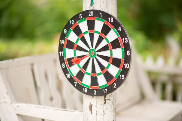 Dart board game hanged on a green wall