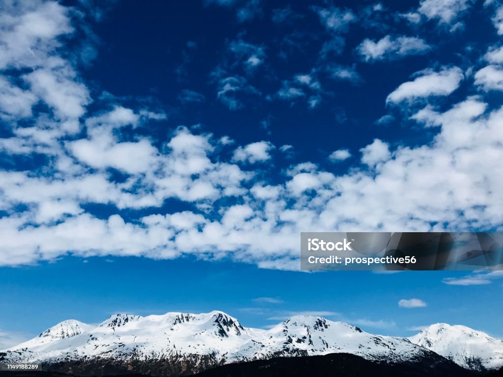 Beautiful cloudscape and snowy mountain ridges in front of Exit Glacier area at Kenai Fjords National Park in Seward Alaska USA Alaska - US State Stock Photo