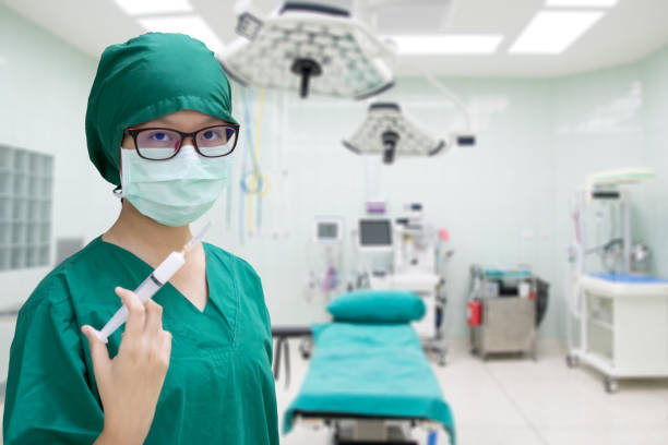 portret chirurga kobiecego z nowoczesną szpitalną salą operacyjną w tle - surgeon isolated paramedic operating room zdjęcia i obrazy z banku zdjęć