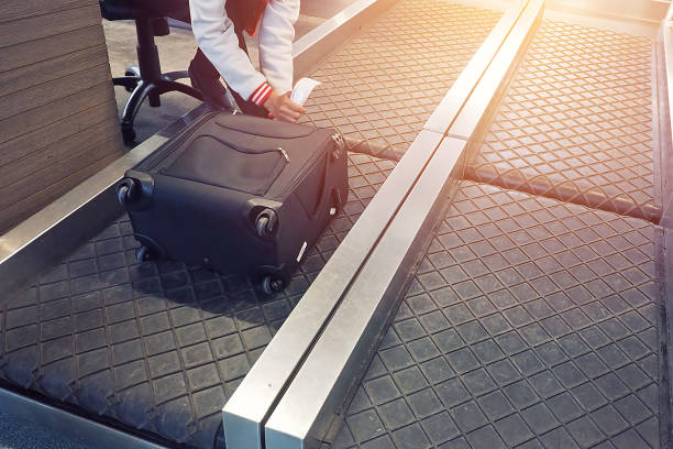 employee attach a luggage tag to suitcase of passenger stock photo