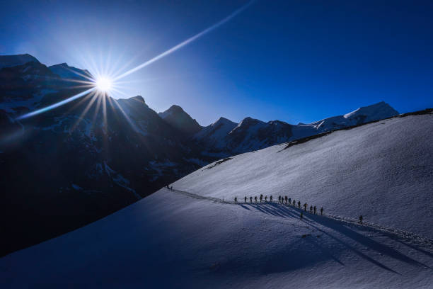 Togetherness concept: Silhoutte a group of hikers with sun at the background during an expedition to Thorong-la Pass via Annapurna Circuit Togetherness concept: Silhoutte a group of hikers with sun at the background during an expedition to Thorong-la Pass via Annapurna Circuit annapurna conservation area photos stock pictures, royalty-free photos & images