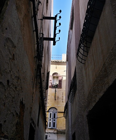 Narrow lane with walls of houses painted in different colors and in poor condition