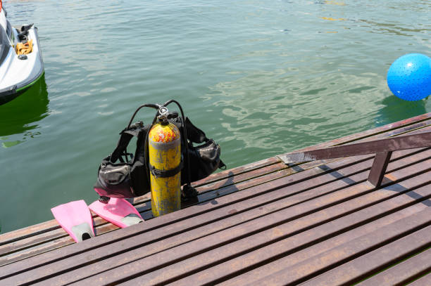 sauerstofftank mit schwimmweste und flossen auf metalltreppen - oxygen tank underwater diving diving wetsuit stock-fotos und bilder