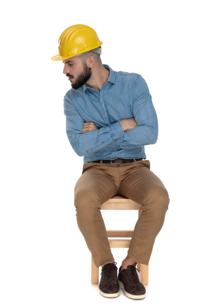 istock seated unshaved man looking close careful with arms folded 1149201944