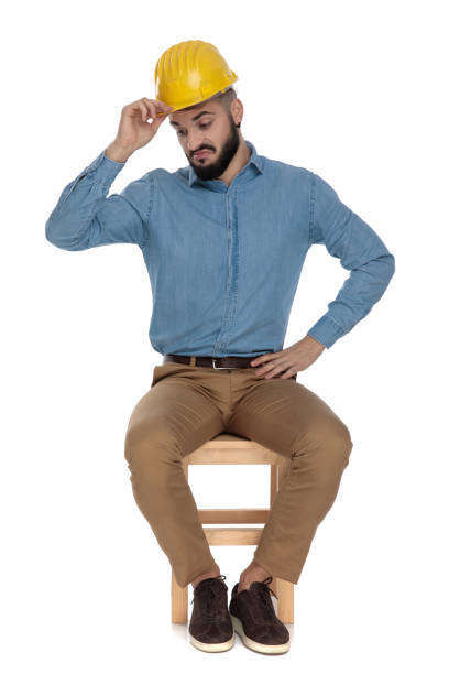 istock seated construction engineer holds hand on his yellow safety helmet 1149202387