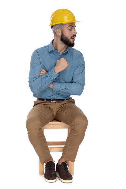 istock handsome man threatening with fist while sitting with arms folded 1149202418