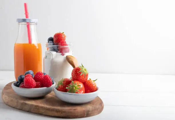 yogurt with strawberries, raspberries and blueberries on a breakfast table. Isolated on a white background