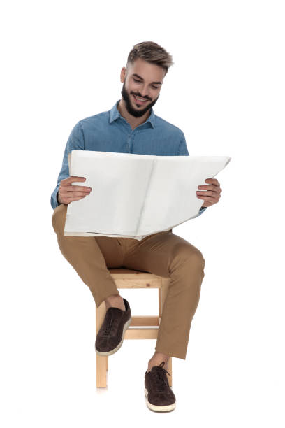 istock seated young man reading good news on newspaper 1149203077