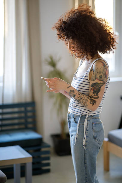 giovane donna tatuata che usa lo smartphone - 2779 foto e immagini stock