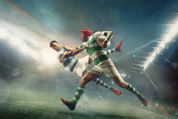 Two caucasian rugby male players in action at the stadium. Fit men in motion or movement with ball. Fighting for the goal. An incredible strain of all forces. Concept of sport, healthy lifestyle.