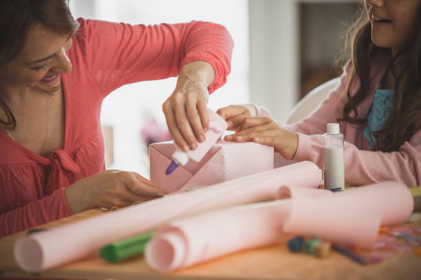 istock Teamwork between mother and daughter while wrapping gifts 1149211062