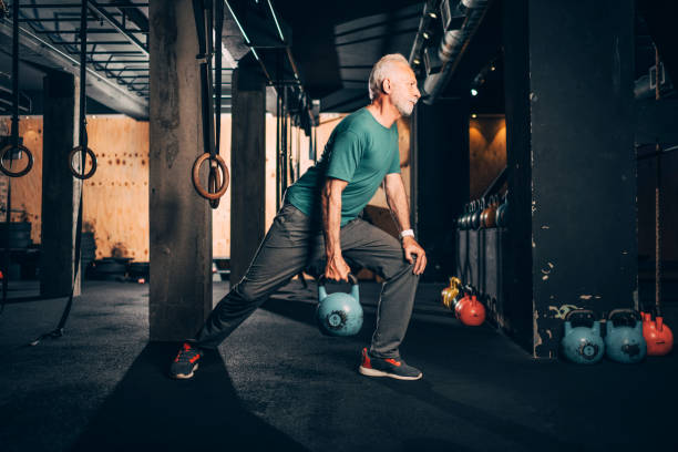 istock Active elderly male doing a one arm kettlebell exercise in a gym gym 1149215979