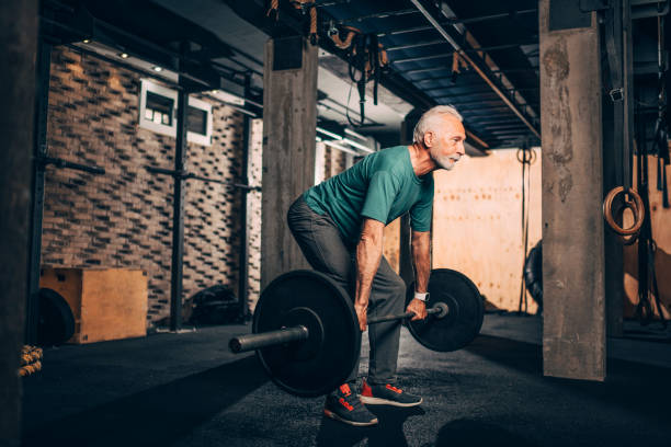 istock Active elderly man doing a deadlift workout in a gym 1149216118