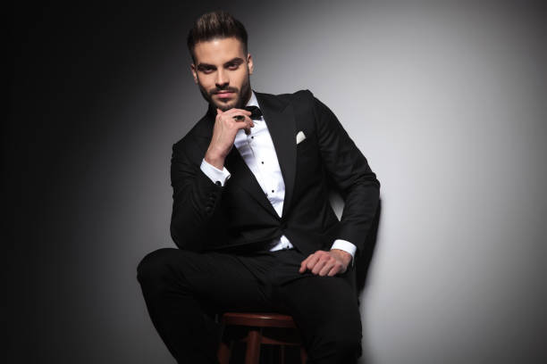 istock seated guy in black tuxedo thinking with hand at chin 1149218017