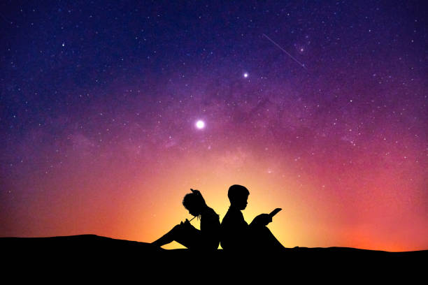 istock Silhouette Boy Using Mobile Phone By Friend Against Sky At Night 1149218538
