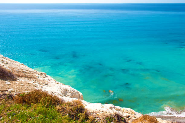 istock View from above on sea surface near Paphos, Cyprus. Warm cloudless fall day. White limestone rock with green grass. Wanderlust. Copy space 1149219155