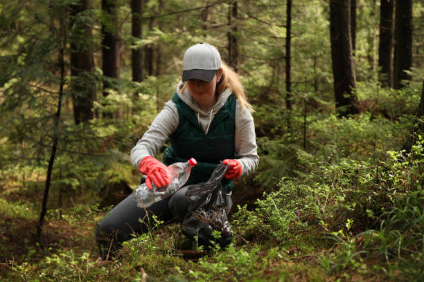 大人の女性ボランティアが、森林の環境を汚染ごみとプラスチックをきれいにする - cleaning environment clean earth ストックフォトと画像