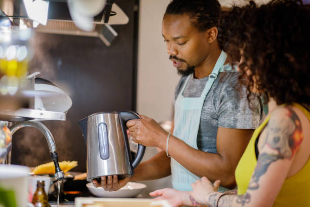 istock Black man holding kettle over sink 1149220034